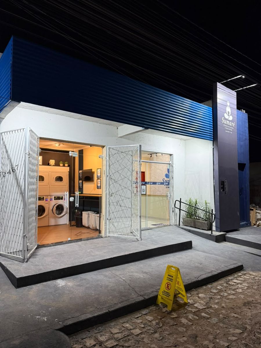 A fachada da Lavaqui Confort à noite, com as portas abertas e as torres acesas lá dentro, ao lado do Sumaré Studio